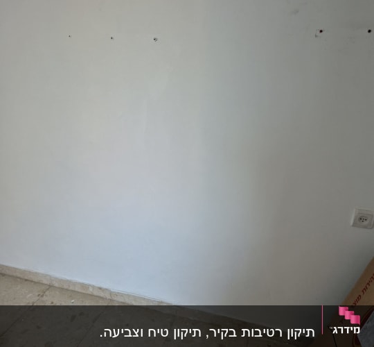 קיר עם חורים וכלי עבודה על הרצפה